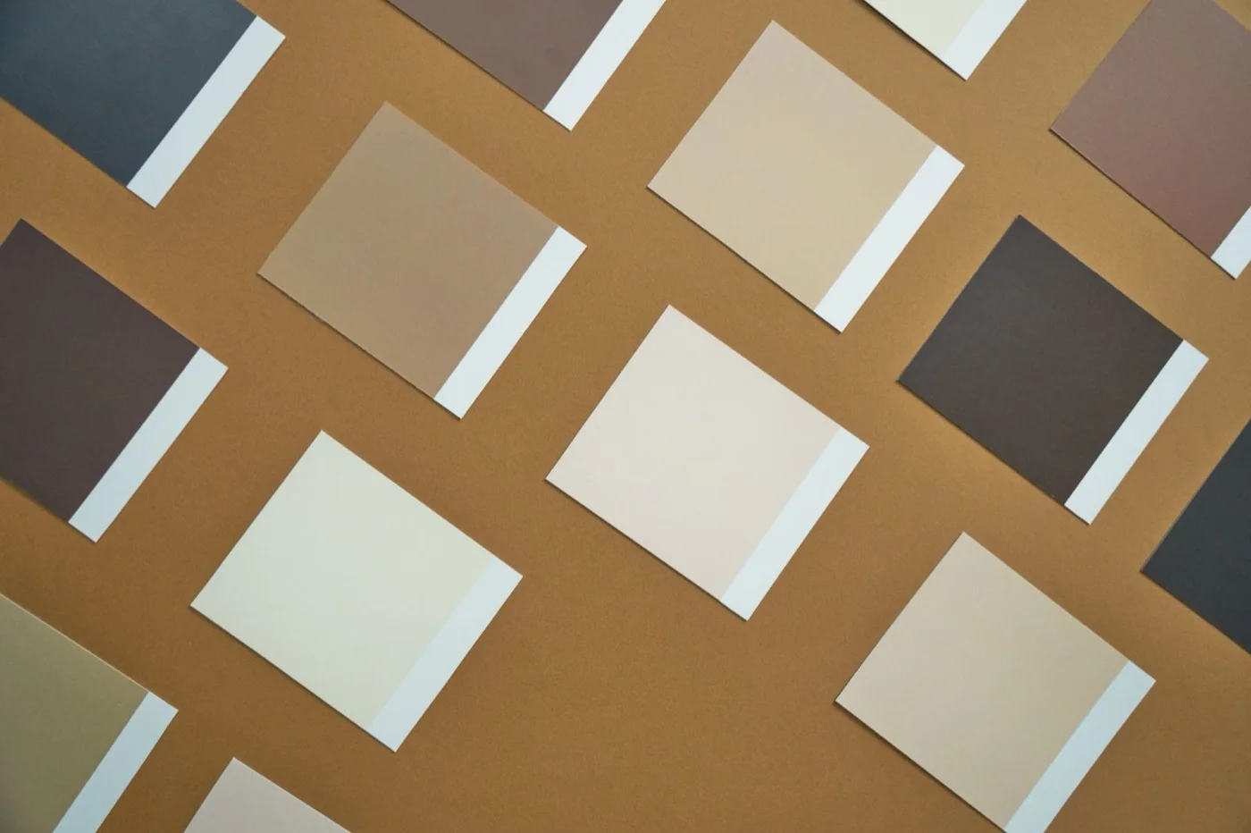 Rechteckige Papiermuster in Beige-, Grau- und Brauntönen, versetzt auf braunem Grund ausgelegt