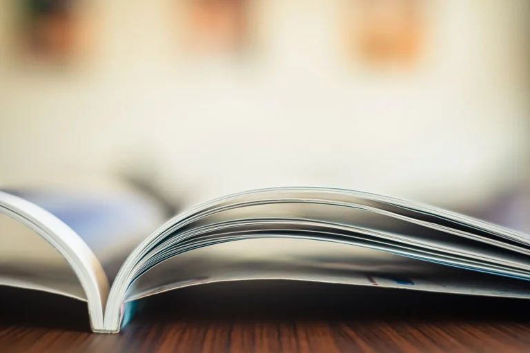Aufgeschlagenes Magazin in Nahaufnahme, die Seiten faechern sich nach oben auf